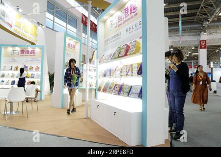 (190821) -- PEKING, 21. August 2019 -- Menschen lesen Bücher im Hong Kong Pavilion während der 26. Internationalen Buchmesse in Peking, Hauptstadt Chinas, 21. August 2019. Die Buchmesse und die 9. China Digital Publishing Expo begannen am Mittwoch am neuen Veranstaltungsort des China International Exhibition Center. ) CHINA-PEKING-BUCHMESSE (CN) JinxLiangkuai PUBLICATIONxNOTxINxCHN Stockfoto