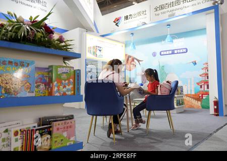 (190821) -- PEKING, 21. August 2019 -- Menschen lesen Bücher während der 26. Internationalen Buchmesse in Peking, Hauptstadt Chinas, 21. August 2019. Die Buchmesse und die 9. China Digital Publishing Expo begannen am Mittwoch am neuen Veranstaltungsort des China International Exhibition Center. ) CHINA-PEKING-BUCHMESSE (CN) JinxLiangkuai PUBLICATIONxNOTxINxCHN Stockfoto