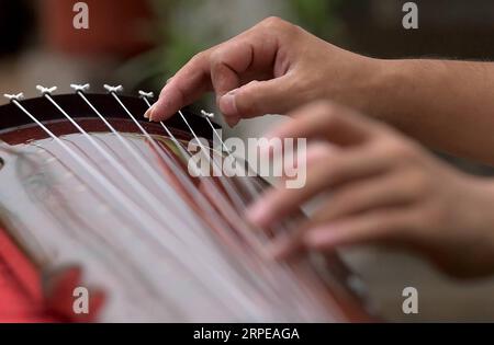 (190823) -- LANKAO, 23. August 2019 -- Xu Bing versucht einen Guqin in seinem Atelier im Dorf Xuchang, Landkreis Lankao in der zentralchinesischen Provinz Henan, 21. August 2019. Xu Bing, geboren 1991, ist ein Dorfbewohner im Dorf Xuchang im Lankao County in Henan. Fasziniert von der traditionellen chinesischen Kultur und Guqin, einem siebensaitigen traditionellen chinesischen Instrument, kehrte Xu Bing nach seinem Abschluss in seine Heimatstadt zurück und begann, die Herstellung und Aufführung von Guqin im Dorf Xuchang zu lernen, das für seine Kultur der Volksinstrumente berühmt ist. Um die Fähigkeit der Herstellung von Guqin zu erlernen, ist dies ein kompliziertes Verfahren Stockfoto