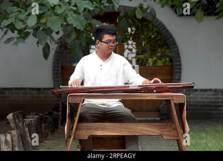 (190823) -- LANKAO, 23. August 2019 -- Xu Bing versucht einen Guqin in seinem Atelier im Dorf Xuchang, Landkreis Lankao in der zentralchinesischen Provinz Henan, 21. August 2019. Xu Bing, geboren 1991, ist ein Dorfbewohner im Dorf Xuchang im Lankao County in Henan. Fasziniert von der traditionellen chinesischen Kultur und Guqin, einem siebensaitigen traditionellen chinesischen Instrument, kehrte Xu Bing nach seinem Abschluss in seine Heimatstadt zurück und begann, die Herstellung und Aufführung von Guqin im Dorf Xuchang zu lernen, das für seine Kultur der Volksinstrumente berühmt ist. Um die Fähigkeit der Herstellung von Guqin zu erlernen, ist dies ein kompliziertes Verfahren Stockfoto