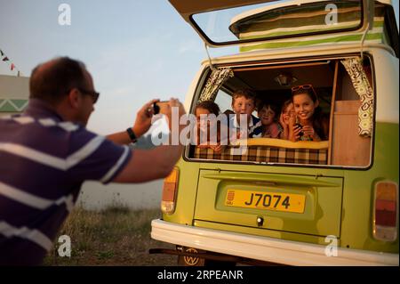 Ein Erwachsener macht ein Foto von fünf Kindern auf der Rückseite eines Wohnmobils. Stockfoto