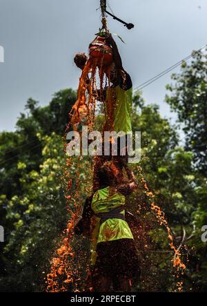 (190824) -- MUMBAI, 24. August 2019 -- Ein Mann steht auf einer menschlichen Pyramide, die von indischen Devotees gebildet wird, um einen Dahi-handi (Quark-Pot) während des Janmashtami Festivals in Mumbai, Indien, 24. August 2019 zu erreichen und zu brechen. Janmashtami ist ein jährliches Festival, das den Geburtstag von Hindu Lord Krishna feiert. (Foto: Fariha Farooqui/Xinhua) INDIA-MUMBAI-FESTIVAL-JANMASHTAMI XinxHuashe PUBLICATIONxNOTxINxCHN Stockfoto