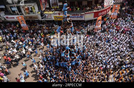 (190824) -- MUMBAI, 24. August 2019 -- indische Devotees bilden eine menschliche Pyramide, um während des Janmashtami Festivals in Mumbai, Indien, am 24. August 2019 einen Dahi-handi (Quark-Topf) zu erreichen und zu brechen. Janmashtami ist ein jährliches Festival, das den Geburtstag von Hindu Lord Krishna feiert. (Foto: Fariha Farooqui/Xinhua) INDIA-MUMBAI-FESTIVAL-JANMASHTAMI XinxHuashe PUBLICATIONxNOTxINxCHN Stockfoto