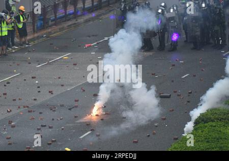 (190825) -- HONG KONG, 25. August 2019 -- radikale Demonstranten schleudern Benzinbomben auf Polizeibeamte in Tsuen Wan, in den westlichen Neuen Territorien des südchinesischen Hongkong, 25. August 2019. Radikale Demonstranten blockieren verschiedene Straßen, werfen Ziegel und Steine auf Polizeibeamte. ) CHINA-HONGKONG-PROTEST-GEWALT (CN) MAOXSIQIAN PUBLICATIONXNOTXINXCHN Stockfoto