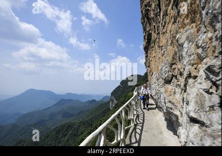 (190827) -- CHONGQING, 27. August 2019 -- Ein touristischer Spaziergang auf einer Plankstraße entlang der steilen Klippe im Jinfo (Golden Buddha) Mountain Scenic Spot im Südwesten Chinas Chongqing, 20. August 2019. ) CHINA-CHONGQING-NANCHUAN-TOURISMUS (CN) LiuxChan PUBLICATIONxNOTxINxCHN Stockfoto