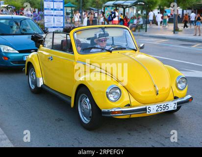 Gelbes Cabriolet mit klassischem Volkswagen Beetle 1303, das durch die Gegend von Sardinero, Santander, Kantabrien, Spanien fährt Stockfoto