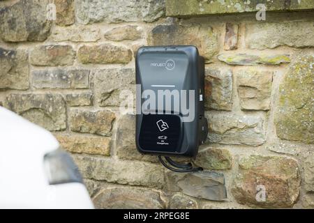 PEAK DISTRICT, GROSSBRITANNIEN - 1. MÄRZ 2023. Ladepunkt für Elektroautos zu Hause (im Inland) an einer Einfahrt, Großbritannien Stockfoto