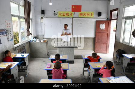 (190829) -- GUIYANG, 29. August 2019 -- Wu Guoxian gibt eine Lektion an Schüler der Gugang Primary School im Dorf Liuguang im Kreis Longli in der autonomen Präfektur Bouyei-Miao von Qiannan, Provinz Guizhou im Südwesten Chinas, 27. August 2019. Die Gugang Primary School im Dorf Liuguang liegt tief in den Bergen und begrüßte sechs Vorschulkinder und vier Erstklässler, als das neue Semester am Montag begann. Sie werden von Wu Guoxian unterrichtet, dem einzigen Schullehrer hier. Wu, 53, arbeitet seit 36 Jahren an der Schule, seit er 1983 an einer Junior High School abschloss. Die Schule hatte ein Dekret Stockfoto