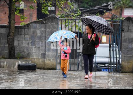 (190829) -- GUIYANG, 29. August 2019 -- Eine Frau schickt ihre Enkelin in die Gugang Primary School im Dorf Liuguang im Kreis Longli in der autonomen Präfektur Qiannan, Provinz Guizhou im Südwesten Chinas, 27. August 2019. Die Gugang Primary School im Dorf Liuguang liegt tief in den Bergen und begrüßte sechs Vorschulkinder und vier Erstklässler, als das neue Semester am Montag begann. Sie werden von Wu Guoxian unterrichtet, dem einzigen Schullehrer hier. Wu, 53, arbeitet seit 36 Jahren an der Schule, seit er 1983 an einer Junior High School abschloss. Die Schule hatte einen abgefallenen Teekorb Stockfoto