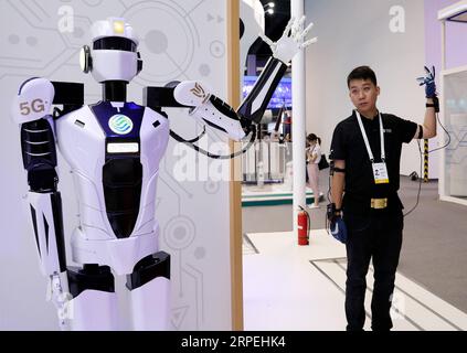 (190829) -- SHANGHAI, 29. August 2019 -- Ein Mitarbeiter (R) demonstriert die 5G-basierte Fernsteuerung eines Roboters während der World Artificial Intelligence Conference (WAIC) 2019 im ostchinesischen Shanghai, 29. August 2019. Die World Artificial Intelligence Conference (WAIC) 2019 findet von Donnerstag bis Samstag im chinesischen Wirtschaftszentrum Shanghai statt, um die KI-Zusammenarbeit und -Innovation weltweit zu fördern. Mit dem Thema „Intelligente Konnektivität, unendliche Möglichkeiten“ konzentriert sich die diesjährige Veranstaltung auf KI-fähige, qualitativ hochwertige Entwicklung, um die gemeinsamen Probleme in der menschlichen Entwicklung zu bewältigen und zu schaffen Stockfoto