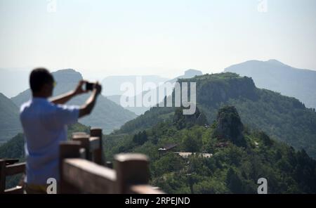 (190830) -- MENGYIN, 30. August 2019 -- Ein Tourist macht Fotos am landschaftlich reizvollen Ort Daigu in der ostchinesischen Provinz Shandong, 30. August 2019. Daigu, eine burgenförmige Landformation, ist eine Landform, die in den zentralen und südlichen Teilen der Provinz Shandong, insbesondere in der Region des Yimeng Mountain, einzigartig ist. Yimengshan Geopark erhielt 2019 das UNESCO Global Geopark Label. CHINA-SHANDONG-GEOPARK-DAIGU LANDFORM (CN) WANGXKAI PUBLICATIONXNOTXINXCHN Stockfoto