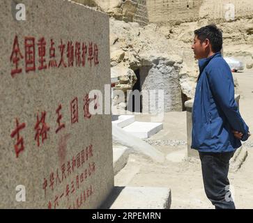 (190901) -- NGARI, 1. September 2019 (Xinhua) -- Basang Cering steht am Eingang der Reliquien des Königreichs Guge in der Provinz Zanda der Präfektur Ngari, der autonomen Region Tibet im Südwesten Chinas, 30. Juli 2019. Jedes Jahr besuchen etwa 100.000 Menschen die Ruinen eines geheimnisvollen antiken Königreichs im Westen Tibets. Die meisten sind Touristen, die kurz durchfahren, aber nicht Basang Cering. Der 30-jährige Mann bewahrt seit 2013 die Reliquien des Königreichs Guge im Zanda County, Präfektur Ngari, der autonomen Region Tibet im Südwesten Chinas. Er studierte eine traditionelle tibetanische Maltechnik namens Thangka in Tibet Stockfoto