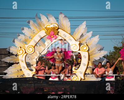 Barranquilla, Atlantico, Kolumbien - 18. Februar 2023: Frauen in weiß und Pink auf einem Float in der Karnevalsparade winken der Menge zu Stockfoto