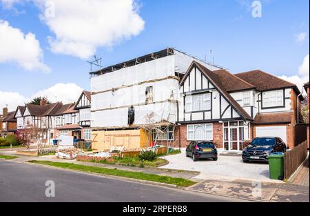 LONDON, Großbritannien - 11. April 2023. Renovierung des Hauses, Doppelhaushälfte in Vorstadt, bedeckt mit Gerüstdecken. Stockfoto