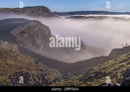 Blick auf Smearsett Narbe im Winter (Dezember) von Pott Narbe mit einer Nebelumkehr, die das Tal darunter füllt. Feizor, Ribblesdale, Yorkshire Dales, North Stockfoto