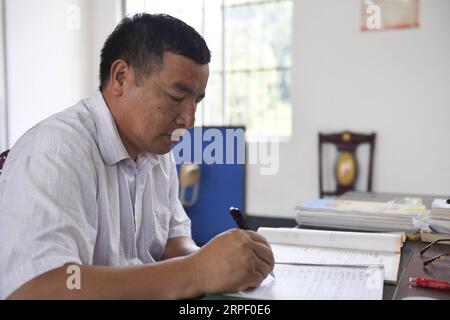 (190908) -- TIANDONG, 8. September 2019 -- Wei Guoji bereitet Unterricht im Büro der Tuogua Primary School im Dorf Tuogua in Zuodeng Yao Ethnic Township des Tiandong County, südchinesische Autonome Region Guangxi Zhuang, 3. September 2019 vor. Die Grundschule Tuogua liegt in abgelegenen Bergen des Tiandong County und ist mehr als 60 km vom County Seat entfernt, zu dem nur eine schroffe Bergstraße führen kann. Der 53-jährige Wei Guoji, ein gebürtiger Bewohner des Dorfes, ist der Direktor der Dorfschule. Wei wurde als Ersatzlehrer der Schule nach dem Abschluss der Mittelschule im Alter von 18 Jahren rekrutiert Stockfoto