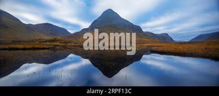 Ein genähtes Panoramabild von Buachaille etive beag und dramatische Wolken, die sich im Herbst in Lochan na fola, Glencoe, Lochaber, Highlands, Schottland, Großbritannien widerspiegeln Stockfoto