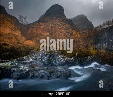 Zwei der drei Schwestern von Glencoe und dem Fluss Coe in Glencoe, Lochaber, Highlands, Schottland, Großbritannien Stockfoto