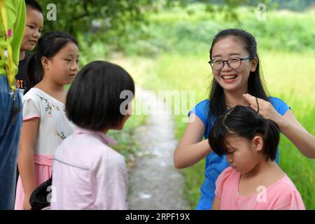 (190909) -- NANCHANG, 9. September 2019 -- Tu Youyou flechtet ein Mädchenhaar im Caojia Village in Luoting Township, Bezirk Wanli der Stadt Nanchang, ostchinesische Provinz Jiangxi, 2. September 2019. Nach dem Abschluss des normalen Hauptstudiums 2013 arbeitete Tu als Assistentin in einer Ausbildungseinrichtung und arbeitete in der Gemeinde, aber sie träumte immer davon, Lehrerin zu werden. 2016 bestand sie die Lehrerprüfung in der Provinz Jiangxi und wurde Landlehrerin. In den letzten drei Jahren hat Tu Youyou die Anerkennung ihrer Eltern gewonnen. Jetzt ist der 29-jährige Landlehrer der Direktor Stockfoto