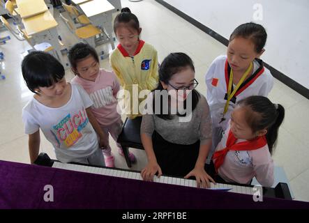 (190909) -- NANCHANG, 9. September 2019 -- Tu Youyou (3. R) spielt Klavier für Schüler an der Shangban-Grundschule in Luoting Township, Bezirk Wanli der Stadt Nanchang, Provinz Jiangxi in Ostchina, 2. September 2019. Nach dem Abschluss des normalen Hauptstudiums 2013 arbeitete Tu als Assistentin in einer Ausbildungseinrichtung und arbeitete in der Gemeinde, aber sie träumte immer davon, Lehrerin zu werden. 2016 bestand sie die Lehrerprüfung in der Provinz Jiangxi und wurde Landlehrerin. In den letzten drei Jahren hat Tu Youyou die Anerkennung ihrer Eltern gewonnen. Jetzt der 29-jährige Landarbeiter Stockfoto