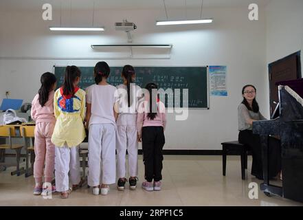 (190909) -- NANCHANG, 9. September 2019 -- Tu Youyou (1. R) spielt eine Begleitung für Schüler an der Shangban-Grundschule in Luoting Township, Bezirk Wanli der Stadt Nanchang, ostchinesische Provinz Jiangxi, 2. September 2019. Nach dem Abschluss des normalen Hauptstudiums 2013 arbeitete Tu als Assistentin in einer Ausbildungseinrichtung und arbeitete in der Gemeinde, aber sie träumte immer davon, Lehrerin zu werden. 2016 bestand sie die Lehrerprüfung in der Provinz Jiangxi und wurde Landlehrerin. In den letzten drei Jahren hat Tu Youyou die Anerkennung ihrer Eltern gewonnen. Jetzt, die 29-Jahr-Ol Stockfoto