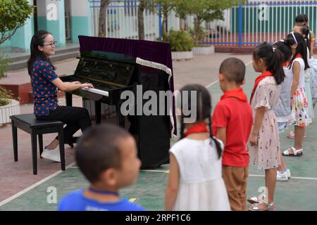 (190909) -- NANCHANG, 9. September 2019 -- Tu Youyou spielt Klavier, um Schüler während einer Eröffnungszeremonie des neuen Semesters an der Shangban-Grundschule in Luoting Township, Bezirk Wanli der Stadt Nanchang, ostchinesische Provinz Jiangxi, zu begrüßen, 1. September 2019, nachdem er 2013 den normalen Hauptschulabschluss gemacht hatte, tu arbeitete als Assistentin in einer Ausbildungseinrichtung und arbeitete in der Gemeinschaft, aber sie träumte immer davon, Lehrerin zu werden. 2016 bestand sie die Lehrerprüfung in der Provinz Jiangxi und wurde Landlehrerin. In den letzten drei Jahren hat Tu Youyou die Anerkennung ihrer stu gewonnen Stockfoto