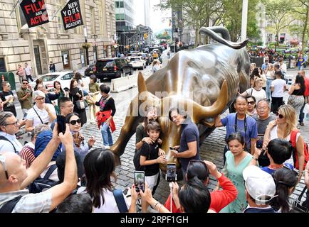 190909 -- NEW YORK, 9. September 2019 -- Touristen posieren für Fotos in der Nähe des beschädigten Wall Street Charging Bull in New York, USA, am 9. September 2019. Ein Mann wurde am 7. September verhaftet, weil er die ikonische Wall Street Charging Bull-Statue in New York mit einem Objekt beschädigt hatte, das einem Banjo ähnelte, berichteten lokale Medien. US-NEW YORK-AUFLADENDE BULLENSCHÄDEN LIXRUI PUBLICATIONXNOTXINXCHN Stockfoto