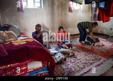 (190910) -- KASHGAR, 10. September 2019 -- Helipat (1. R) und seine Familie packen Kleidung, um sich auf den Umzug in ihrem alten Haus im Dorf Qipan im Yecheng County in Kashgar vorzubereiten, nordwestchinesische Autonome Region Xinjiang Uygur, 18. August 2019. Dank der Umsiedlungsprojekte der Armutsbekämpfungspolitik wird Helipats Familie bald in ihr neues Zuhause im County ziehen. Um die Mission zu erfüllen, die absolute Armut bis 2020 zu beseitigen, hat Xinjiang verarmten Bauern und Hirten geholfen, aus Bergregionen und Wüstenhinterland zu ziehen, um sich in Ebenen und Oasen neu anzusiedeln. Ende 2 Stockfoto