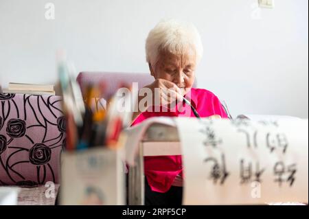 (190913) -- SUIHUA, 13. September 2019 -- Jiang Shumei praktiziert Kalligraphie zu Hause im Beilin-Bezirk der Stadt Suihua, nordöstliche chinesische Provinz Heilongjiang, 12. September 2019. Jiang wurde 1937 geboren und war vor seinem 60. Lebensjahr Analphabet. Um Jiangs Not nach dem Tod ihres Mannes im Jahr 1996 bei einem Autounfall zu lindern, lehrte ihre Tochter Zhang Aailing seither die ältere Frau Lesen und Schreiben. Mit der Ermutigung ihrer Tochter versuchte Jiang, ein Buch zu schreiben. 2013 erschien Jiangs erstes Buch. Bisher hat der 82-jährige Schriftsteller fünf Bücher veröffentlicht und mehrere Preise gewonnen. ) CHINA-HEILONGJI Stockfoto