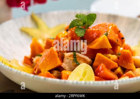 Ceviche mit Papaya ist auf dem Teller, Nahaufnahme mit selektivem Weichzeichner. Dies ist ein Gericht, das aus Fisch oder Schalentieren besteht, die in Zitrusfrüchten und mariniert sind Stockfoto