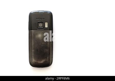 Altes, gut gebrauchtes dummes Mobiltelefon Nokia 6303 ci mit einer 3,2-Megapixel-Kamera, Blitzdiode, Metallakkuabdeckung. Low-Tech-Konzept für altmodische Mobilgeräte. Stockfoto