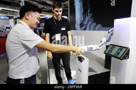 (190917) -- SHANGHAI, 17. September 2019 -- Ein Besucher schüttelt während der China International Industry Fair 2019 im ostchinesischen Shanghai, 17. September 2019 mit einem bionischen Roboter die Hand. Die Messe findet vom 17. Bis 21. September mit über 2.600 Ausstellern aus 27 Ländern und Regionen statt. ) CHINA-SHANGHAI-CIIF-OPENING (CN) FangxZhe PUBLICATIONxNOTxINxCHN Stockfoto