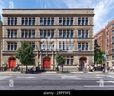 Upper West Side: School of the Holy Name of Jesus ist ein unsinniges, düsteres, graues Ziegel- und Steingebäude, das nur von bogenförmigen, rot bemalten Türen belebt wird. Stockfoto