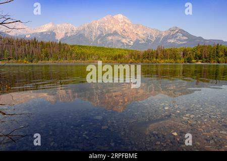 Der Berg spiegelt sich im Herbst in einem ruhigen klaren See wider Stockfoto