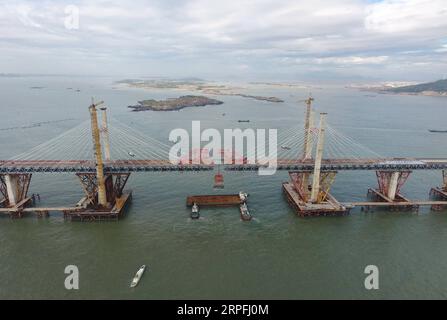 190925 -- FUZHOU, 25. September 2019 -- Luftaufnahme vom 21. September 2019 zeigt einen Stahlträger, der von einem Kran auf der Baustelle der Pingtan Strait Road-Rail Bridge in der südöstlichen chinesischen Provinz Fujian angehoben wird. Am Mittwoch vollendete China die Hauptstruktur der weltweit längsten überseeischen Straßen-Schiene-Brücke in Fujian. Der letzte Stahlträger mit einem Gewicht von 473 Tonnen wurde am Mittwochmorgen auf der Pingtan Strait Road-Rail Bridge, einem weiteren Megaprojekt in China, verschraubt. Mit einer atemberaubenden Spannweite von 16,34 km verbindet die Brücke die Insel Pingtan und vier nahe gelegene Inseln mit dem Festland von Fujian Pro Stockfoto