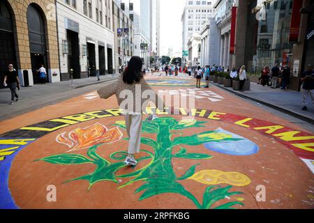 190926 -- SAN FRANCISCO, 26. September 2019 -- A Woman Walks on the Ground Painting Theme on Environmental Protection at Montgomery Street in San Francisco, USA, 25. September 2019. Insgesamt 13 Bodenbilder zum Thema Umweltschutz wurden am Mittwoch in San Francisco geschaffen, um die Verringerung des Verbrauchs fossiler Brennstoffe und Investitionen in grüne Energie zu fordern. Foto von Xinhua/ U.S.-SAN FRANCISCO-GROUND PAINTING-ENVIRONMENTAL PROTECTION LixJianguo PUBLICATIONxNOTxINxCHN Stockfoto