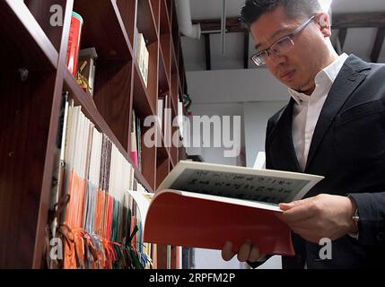 190927 -- PEKING, 27. September 2019 -- Chen Nan sucht ein Nachschlagewerk in seinem Atelier an der Tsinghua Universität in Peking, Hauptstadt Chinas, 24. September 2019. Mit einer Geschichte von mehr als 3.000 Jahren hat oracle Bone Script, die frühesten chinesischen Schreibinschriften, die auf Schildkrötenschalen und Tierscapulas gemeißelt wurden, dank der Bemühungen von Chen Nan moderne Bedeutungen mit einer neuen Reihe von Emojis erhalten. Chen, ein Professor an der Akademie der Künste und des Designs der Tsinghua Universität, widmet sich seit 1999 dem Studium und dem Design von oracle Bone Script. Bis jetzt hat Chen sechs Sätze von an herausgegeben Stockfoto