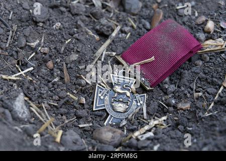 Eine Victoria Cross-Medaille (Nachbildung), die im Dreck vergessen wurde Stockfoto