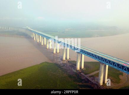 190928 -- ORDOS, 28. September 2019 -- Luftaufnahme, aufgenommen am 18. September 2019, zeigt eine Yellow River Autobahn-Eisenbahnbrücke auf der Haoji Railway. Die Haoji Railway, eine Schwerlastbahn für den Kohletransport, die sich über 1.800 km erstreckt, wurde am Samstag in China für den Verkehr eröffnet, so China Railway Xi an Group Co., Ltd Als eine der längsten Schwerlasteisenbahnen der Welt beginnt die Haoji-Bahn von Haolebaoji in der Stadt Ordos in der Autonomen Region Innere Mongolei im Norden Chinas und endet in Ji an City in der ostchinesischen Provinz Jiangxi, die sieben Provinzen umfasst, darunter Shaanxi, Henan und Hubei. Pho Stockfoto