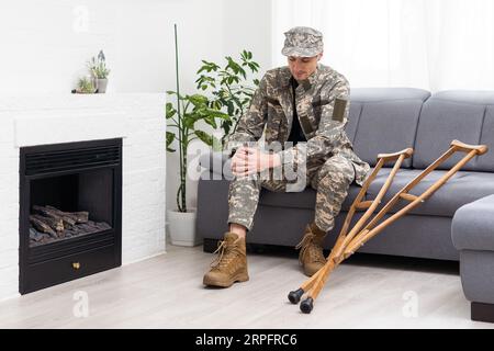 Soldat in Khaki-Militäruniform auf Krücken Stockfoto