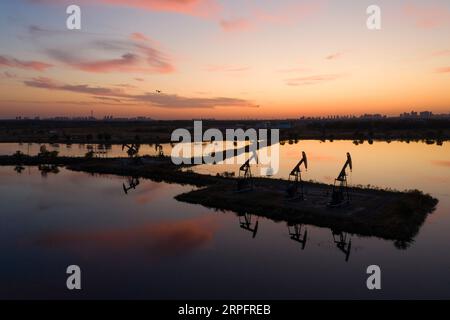 190930 -- DAQING, 30. September 2019 -- Luftaufnahme aufgenommen am 27. September 2019 zeigt die Sonnenuntergangslandschaft am Daqing Oilfield in Daqing, nordöstliche chinesische Provinz Heilongjiang. Daqing Oilfield, entdeckt am 26. September 1959, ist das größte Ölfeld, das von PetroChina betrieben wird und auch die größte Ölförderbasis des Landes ist. Das Ölfeld, auf das einst mehr als die Hälfte der gesamten Rohölproduktion Chinas entfiel, hatte eine jährliche Rohölproduktion von über 50 Millionen Tonnen in 27 aufeinanderfolgenden Jahren und von über 40 Millionen Tonnen in 12 aufeinanderfolgenden Jahren. Die jährliche Erdöl- und Erdgasproduktion liegt nach wie vor bei über 40 Millionen Tonnen Öläquivalent Stockfoto
