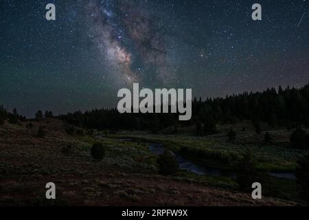 Die Milchstraße „türmt“ sich über dem Malheur River in Oregon südlich der Strawberry Mountain Wilderness, USA Stockfoto