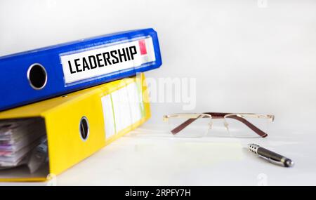 Definition des Wortes Leadership in einem blauen Ordner auf weißem Hintergrund Stockfoto