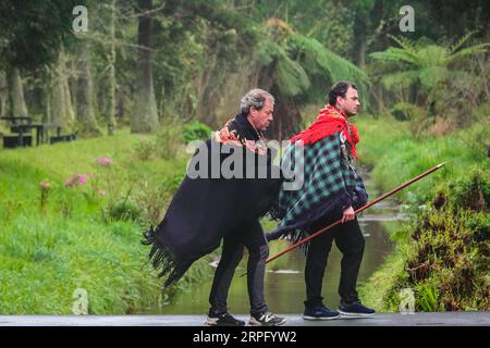 Römisch-katholische Pilger, genannt Romeiros, gehen weiter, nachdem sie ein einfaches Mittagessen während ihrer 8-tägigen Wanderung um die Azoreninsel Sao Miguel, am 30. März 2023 in Furnãs, Portugal, genossen haben. Die Pilger besuchen 100 Schreine und Kirchen während der Veranstaltung aus dem Jahr 1522, als ein Erdbeben die ersten Siedlungen zerstörte. Stockfoto