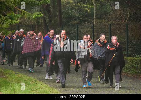 Römisch-katholische Pilger, genannt Romeiros, gehen auf einer Landstraße in Nebel und Regen während ihrer 8-tägigen Wanderung um die Azoreninsel Sao Miguel, am 30. März 2023 in Furnãs, Portugal. Die Pilger besuchen 100 Schreine und Kirchen während der Veranstaltung aus dem Jahr 1522, als ein Erdbeben die ersten Siedlungen zerstörte. Stockfoto