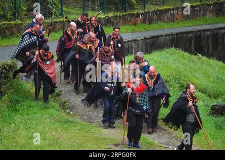Römisch-katholische Pilger, genannt Romeiros, wandern zum Rand des Furnasees für eine Predigt in Nebel und Regen während ihrer 8-tägigen Wanderung um die Azoreninsel Sao Miguel, am 30. März 2023 in Lagoa das Furnãs, Portugal. Die Pilger besuchen 100 Schreine und Kirchen während der Veranstaltung aus dem Jahr 1522, als ein Erdbeben die ersten Siedlungen zerstörte. Stockfoto