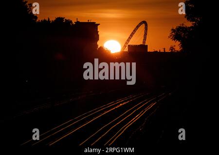 Die Sonne untergeht hinter dem Arch Wembley Stadium im Westen Londons. Bilddatum: Montag, 4. September 2023. Stockfoto