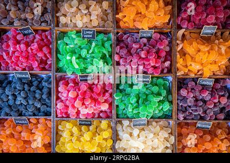 Süße Süßigkeiten in verschiedenen Farben und Texturen, im Vordergrund, mit Zucker auf der Oberseite und auf einem rustikalen Holzbehälter Stockfoto