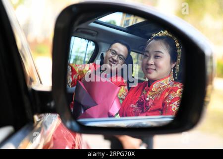 191005 -- TONGREN, 5. Oktober 2019 -- Bräutigam Pan Rongdong L und Braut Tan Lifei werden in einem Hochzeitsauto in der Stadt Tongren, südwestchinesische Provinz Guizhou, 4. Oktober 2019 gesehen. Pan Rongdong ist ein Mitarbeiter des Gesundheitszentrums für Mütter und Kinder im Bezirk Wanshan in Tongren. Im September 2017, als Pan in das Dorf Wengbei in der Gemeinde Aozhai in Wanshan geschickt wurde, um an der Armutsbekämpfung zu arbeiten, lernte er Tan Lifei kennen, den Direktor der Armutsbekämpfungsstation für Aozhai. Während ihrer Arbeit zur gezielten Armutsbekämpfung halfen Pan und Tan und kümmerten sich um jeden Stockfoto