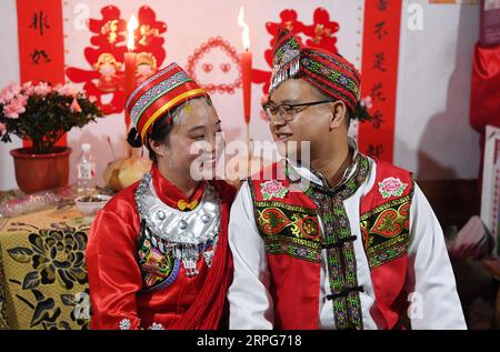 191005 -- TONGREN, 5. Oktober 2019 -- der Bräutigam Pan Rongdong und die Braut Tan Lifei werden während ihrer Hochzeitszeremonie in Tans Heimatstadt Baihe Village in Ganxi, Stadt Tongren, südwestchinesische Provinz Guizhou, 3. Oktober 2019 gesehen. Pan Rongdong ist ein Mitarbeiter des Gesundheitszentrums für Mütter und Kinder im Bezirk Wanshan in Tongren. Im September 2017, als Pan in das Dorf Wengbei in der Gemeinde Aozhai in Wanshan geschickt wurde, um an der Armutsbekämpfung zu arbeiten, lernte er Tan Lifei kennen, den Direktor der Armutsbekämpfungsstation für Aozhai. Bei der Arbeit an gezielten bestellungen Stockfoto